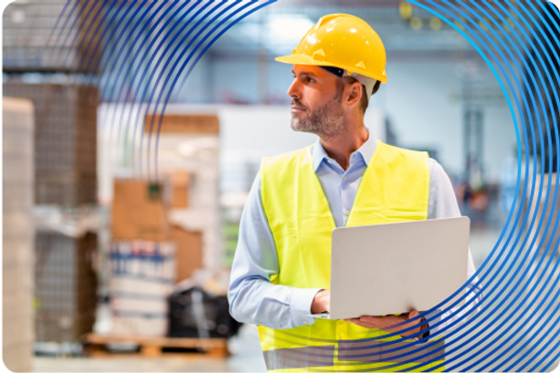 Facility engineer holding laptop in warehouse