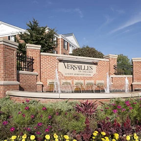 Ground-level view of Versailles on the Lakes living complex, showcasing smart access upgrades