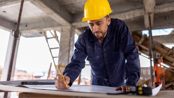 Construction worker in yellow helmet, symbolizing support for builders and integrators using myQ smart access solutions