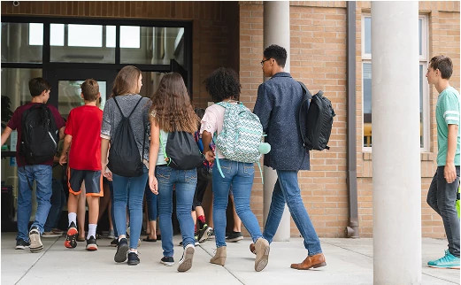 Students entering a school building, representing secure, monitored access for educational environments