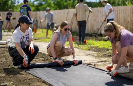 Chamberlain Group interns working together on an outdoor field community service project