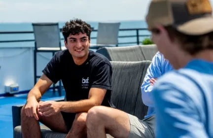 Group of corporate interns sitting outside laughing and connecting during an outing